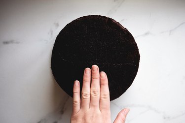 Use a knife or cake leveller to cut the cake layers until they are completely flat.