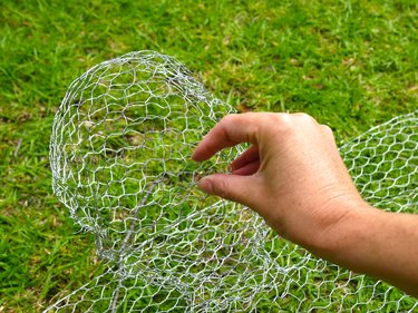 A hand pinching the wire to make a nose.