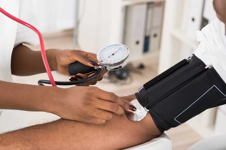 Close-up Of Doctor Measuring Patients Blood Pressure With Stethoscope